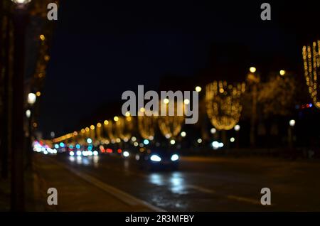 Vue floue de la rue avec de belles lumières sur les arbres et les voitures la nuit. Effet bokeh Banque D'Images