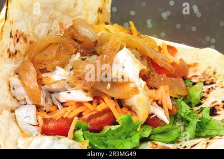 Poisson avec oignons et salade dans une tortilla. Banque D'Images