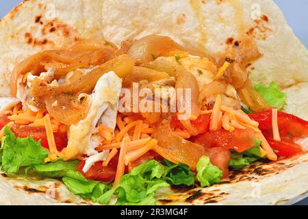 Poisson avec oignons et salade dans une tortilla. Banque D'Images