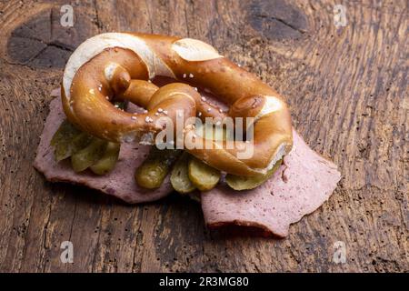 Leberkäse in einer Brezel auf Holz Banque D'Images