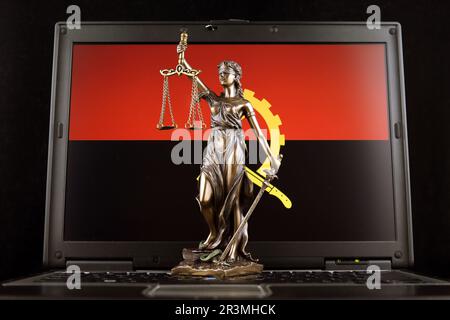 Symbole de la loi et de la justice avec l'Angola drapeau sur ordinateur portable. Prise de vue en studio. Banque D'Images