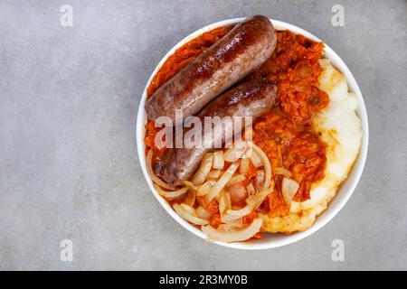 Pap et Wors sud-africains traditionnels, saucisse avec aliment de base populaire de maïs recouvert de Chakalaka ou relish sur gris marbré avec espace de copie Banque D'Images