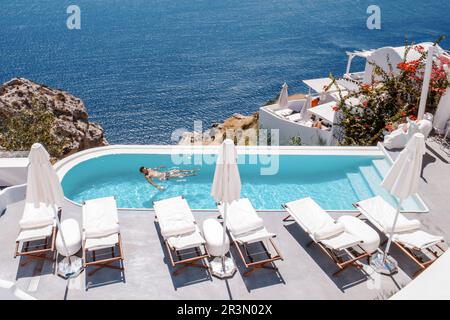 Santorini Greece Oia, jeunes hommes à la piscine avec vue sur l'océan de la caldeira Banque D'Images