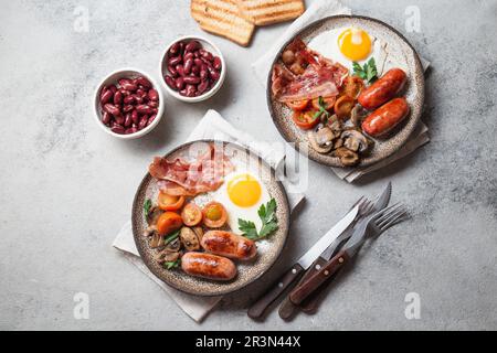 Petit-déjeuner anglais sur des assiettes grises sur fond blanc Banque D'Images