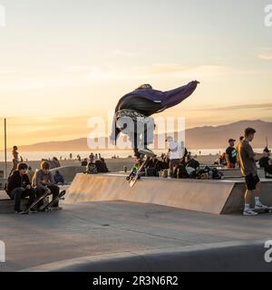 Plage de Venise, Californie, États-Unis - 15 mars 2022 : un pilote en action au célèbre parc à roulettes de Venise au coucher du soleil Banque D'Images