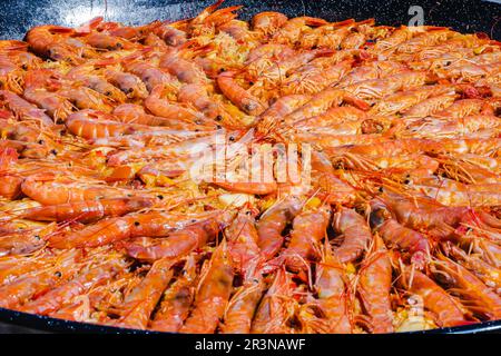 Grand angle de délicieux crevettes tigrées sautées préparées et sautées dans une sauce au beurre sur une poêle métallique au restaurant Banque D'Images