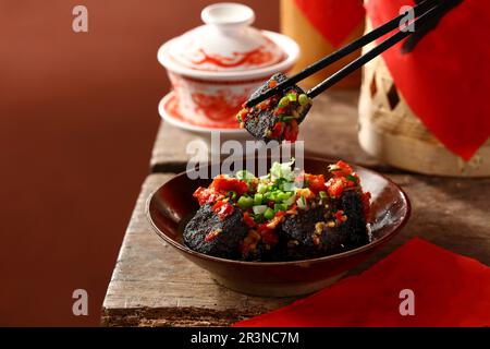 Le tofu stinky est une forme chinoise de tofu fermenté qui a une forte odeur. Tofu frits de style Hunan, à l'huile de Chili et à l'oignon de printemps. Banque D'Images