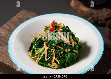 Épinards SAUTÉS avec des morceaux de tofu séchés Banque D'Images