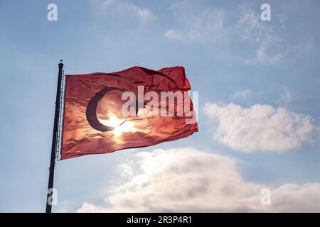 Une photo du drapeau turc contre un ciel bleu nuageux. Banque D'Images