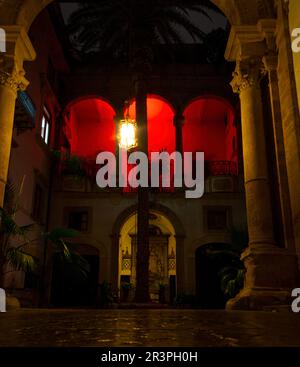 Palerme, Italie - 22 décembre 2022: Cour du Palazzo Castrone Santa Ninfa illuminée de feux rouges. Banque D'Images