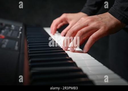 Lecture du synthétiseur de piano sur fond sombre Banque D'Images