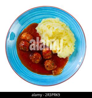 Assiette ronde blanche avec boulettes de viande saupoudrées d'aneth haché dans une sauce tomate avec purée de pommes de terre Banque D'Images