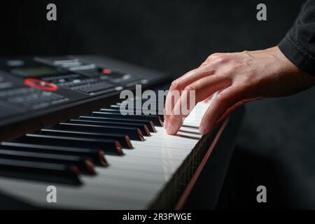 Lecture du synthétiseur de piano sur fond sombre Banque D'Images