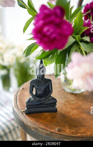 Statue de Bouddha en pierre noire sur un arrière-plan confortable de la salle de lumière Banque D'Images