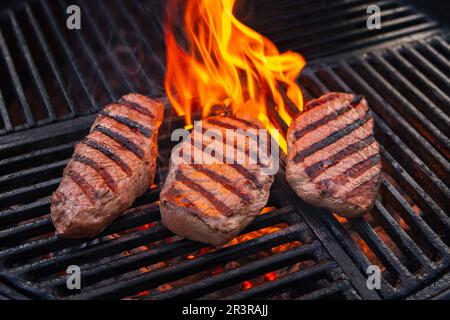 Griller au barbecue le steak de sirloin Angus vieilli grillé comme gros plan sur un grill au charbon de bois avec feu et fumée Banque D'Images