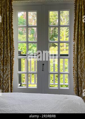Fenêtre avec belle vue sur le jardin dans une chambre confortable. Design intérieur Banque D'Images