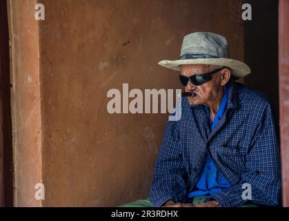 Vinales, Cuba - 25 mai 2018 : un vieil homme cubain dans un chapeau de cow-boy et des lunettes de soleil fume un cigare Banque D'Images