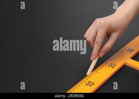 Femme dessin avec craie et règle triangulaire sur tableau noir, gros plan. Espace pour le texte Banque D'Images