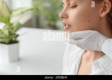 Dermatologue examinant les grains de beauté sur le visage de la jeune femme en clinique, en gros plan Banque D'Images