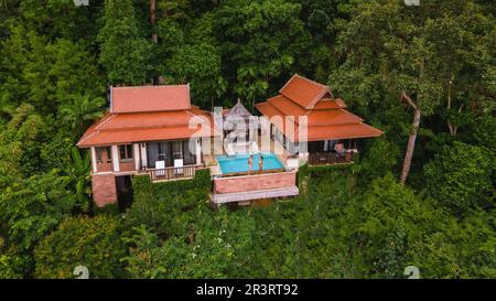 Couple hommes et femme en vacances de luxe dans une villa de piscine dans la forêt tropicale de la jungle Banque D'Images