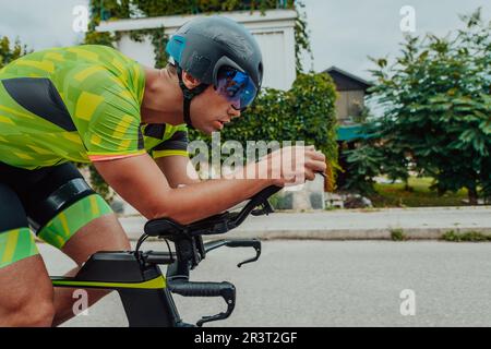 Portrait complet d'un triathlète actif en vêtements de sport et avec un casque de protection à vélo. Mise au point sélective Banque D'Images