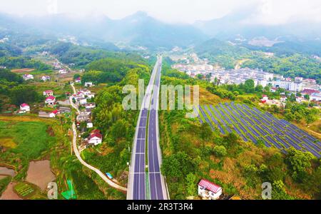 ANQING, CHINE - 25 MAI 2023 - On voit des collines vertes, des routes et des panneaux photovoltaïques solaires dans le village de Tengyun, la ville d'Anqing, la province d'Anhui, en Chine, au 2 mai Banque D'Images