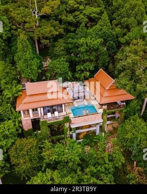 Couple d'hommes et de femmes en vacances de luxe dans une villa de piscine dans la forêt tropicale de la jungle Banque D'Images