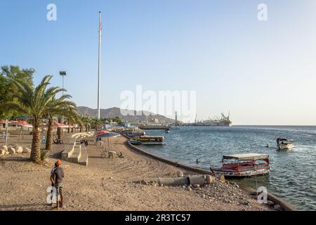 Coucher de soleil sur la plage d'Aqaba, fenêtre de la Jordanie sur la mer Rouge. En arrière-plan, l'impressionnant Flagpole et les installations portuaires Banque D'Images