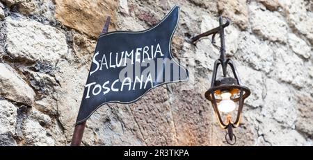 La toscane, italie. Boucherie traditionnelle streetsign sur un vieux mur Banque D'Images