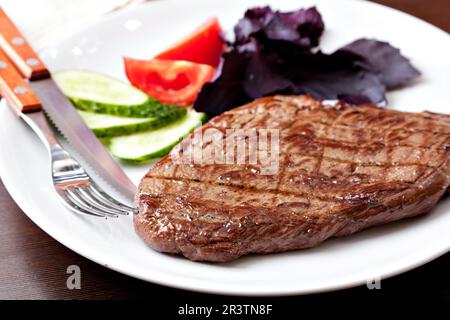 Steak grillé sur une assiette blanche Banque D'Images