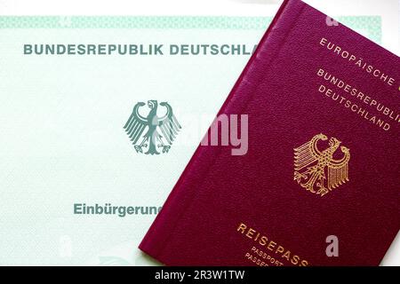 Berlin, Allemagne. 22nd mai 2023. Un certificat de naturalisation de la République fédérale d'Allemagne (l) et un passeport allemand se trouvent sur une table. Les étrangers en Allemagne seront bientôt en mesure d'obtenir la citoyenneté allemande plus facilement, selon les plans du gouvernement fédéral. Credit: Fernando Gutierrez-Juarez/dpa/Alay Live News Banque D'Images