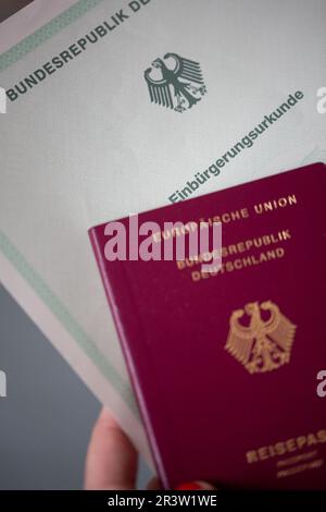 Berlin, Allemagne. 22nd mai 2023. Une personne est titulaire d'un certificat de naturalisation de la République fédérale d'Allemagne et d'un passeport allemand. Les étrangers en Allemagne seront bientôt en mesure d'obtenir la citoyenneté allemande plus facilement, selon les plans du gouvernement fédéral. Credit: Fernando Gutierrez-Juarez/dpa/Alay Live News Banque D'Images