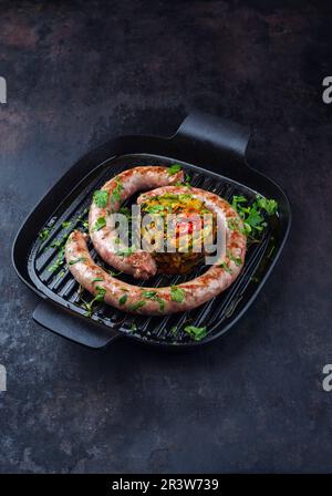 Saucisse italienne traditionnelle salsiccia à la fresque, servie avec tartre aux légumes et coriandre dans une casserole en fonte Banque D'Images