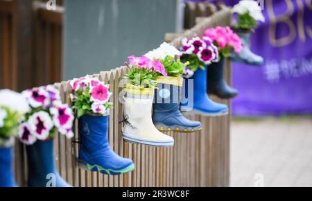 Hanovre, Allemagne. 25th mai 2023. Des bottes en caoutchouc pour enfants avec fleurs sont accrochées à une clôture dans un centre de garderie de la région de Hanovre. Jeudi, une conférence sur "assurer la qualité de l'éducation dans les garderies - lutter contre la pénurie de travailleurs qualifiés" se tiendra à Hanovre. Credit: Julian Stratenschulte/dpa/Alay Live News Banque D'Images