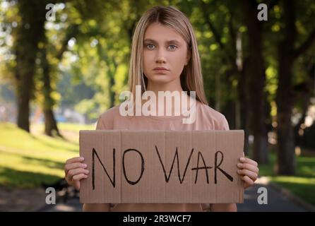 Triste femme tenant une affiche avec des mots No War dans le parc Banque D'Images