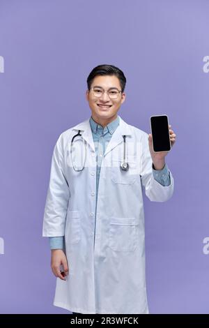 Homme médecin homme porte le stéthoscope, montrer le téléphone portable écran vide Banque D'Images