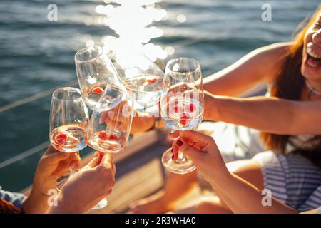 Coucher de soleil sur le ciel et la mer en arrière-plan. Faire un toast de fête avec du vin mousseux Banque D'Images