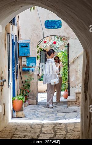 Tel Aviv, Israël - 18 mai 2023: Les touristes aiment marcher dans la vieille ville de tel Aviv avec de vieilles arches pittoresque, des maisons et des cours. Banque D'Images