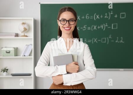 Portrait du jeune professeur de mathématiques près du tableau noir en classe Banque D'Images