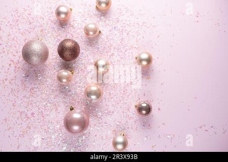 Décoration de Noël de boules sur fond rose avec guirlande. Plan de travail avec espace de copie Banque D'Images