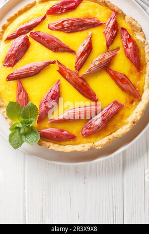 Gâteau sablé croustillant avec crème anglaise et rhubarbe dans une assiette sur la table. Vue verticale du dessus Banque D'Images