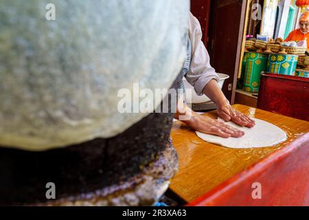 Faire de la pâte phyllo sur une boule de pierre chaude, Fès, maroc, afrique. Banque D'Images