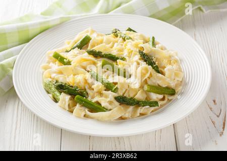 Asperges pâtes avec zeste de citron et parmesan sur l'assiette de la table en bois. Horizontale Banque D'Images