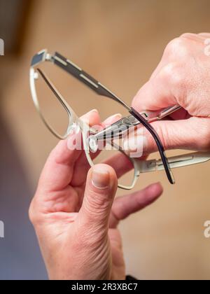 Opticien préparant une paire de lunettes. Réglage des patins de nez Banque D'Images