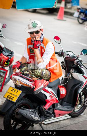 Un pilote de moto thaï très cool qui travaille comme un service de taxi prend une pause assis dans son vélo à Pattaya en Thaïlande. Banque D'Images