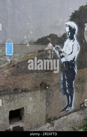 Boy Fishing : Street Art de style Banksy sur une fortification de boîte à pilules de la Seconde Guerre mondiale à Harwich, Essex, Royaume-Uni Banque D'Images