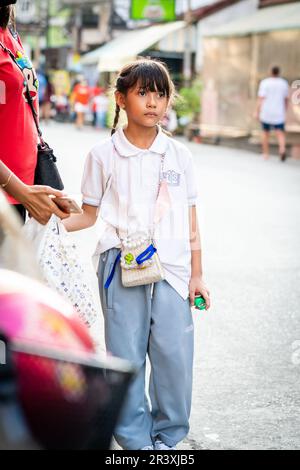 Une jeune fille thaïlandaise attend un trajet à la maison après l'école dans la ville de Thaïlande de Pattaya. Banque D'Images