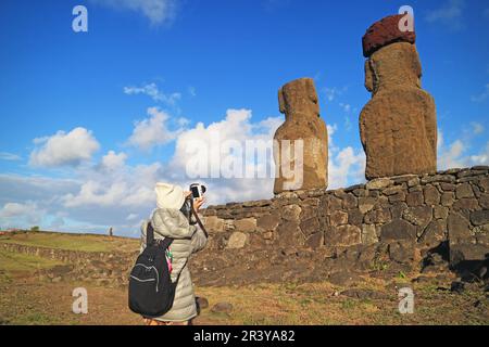 La femme voyageur photographiant à l'arrière de gigantesques statues Moai à la plate-forme de cérémonie AHU Tongariki, Île de Pâques, Chili, Amérique du Sud Banque D'Images