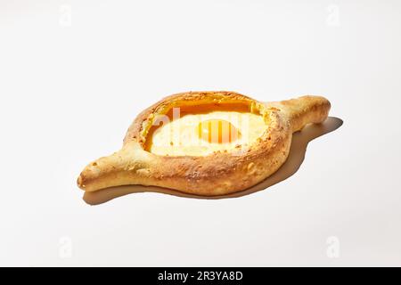 Adjarian khachuri sur fond blanc. Plat traditionnel de cuisine géorgienne, bateau à pâte avec fromage et jaune d'œuf Banque D'Images