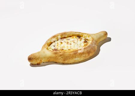 Adjarian khachuri sur fond blanc. Une version non conventionnelle de la cuisine géorgienne, bateau à pâte avec du fromage et de la viande Banque D'Images